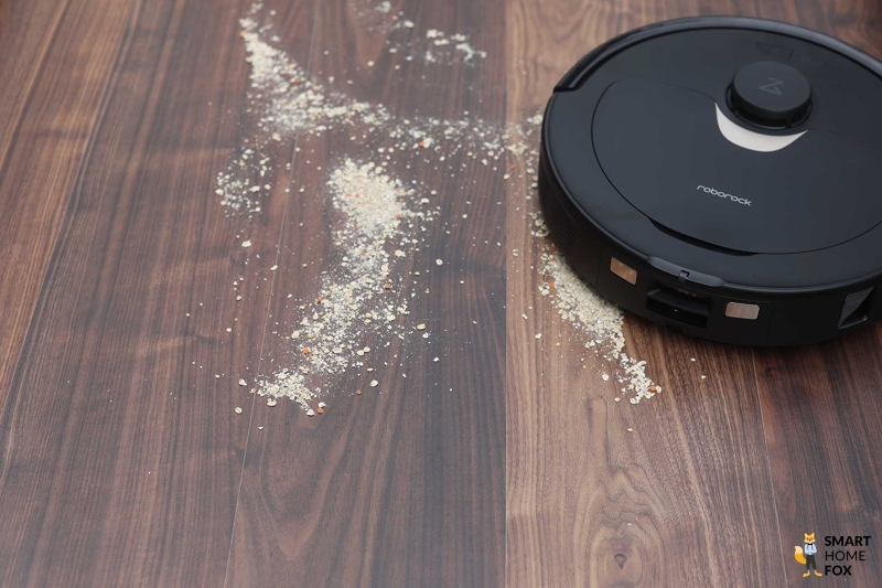 Roborock Q Revo убирает овсяные хлопья во время теста на ламинате.